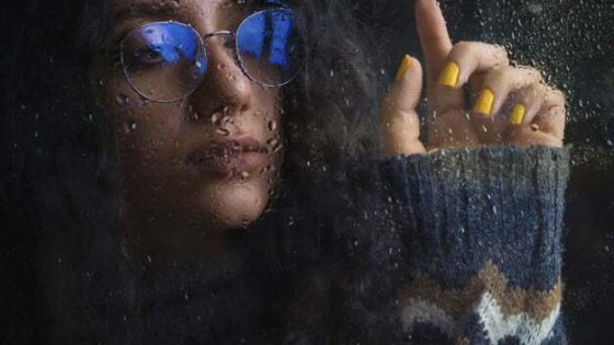 Woman in optique glasses with blue shadow and warm knit jacket