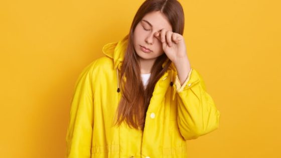 tired-woman-wearing-yellow-jacket-rubbing-her-eye-female-with-long-beautiful-hair-posing-with-closed-eyes-looks-exhausted-standing-against-bright-wall_176532-7313